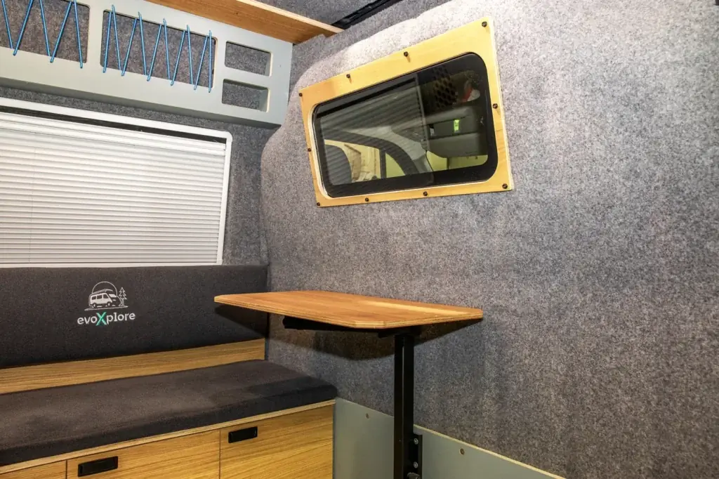 Sitzbank mit Einhängetisch, Fenster mit Holzrahmen und Plissee